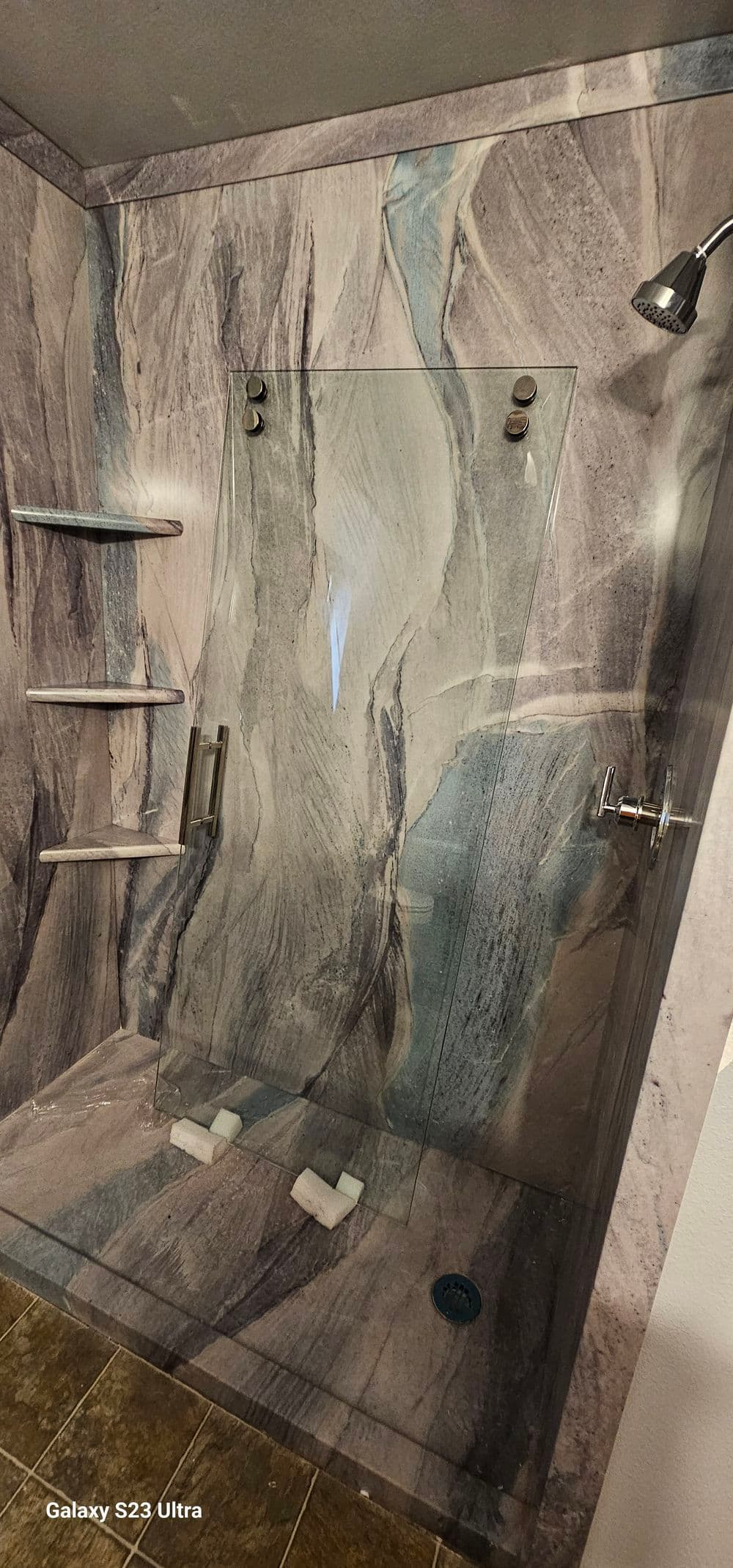 Modern glass shower design with marble walls and stylish fixtures. Clean and spacious.