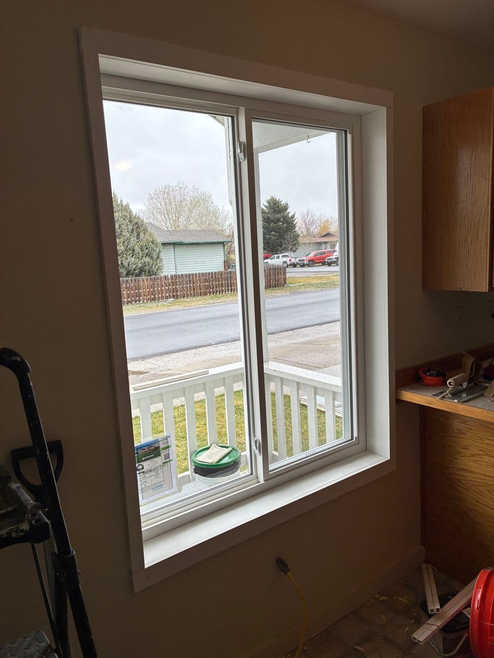 Newly installed window with a view of a suburban street and greenery outside.
